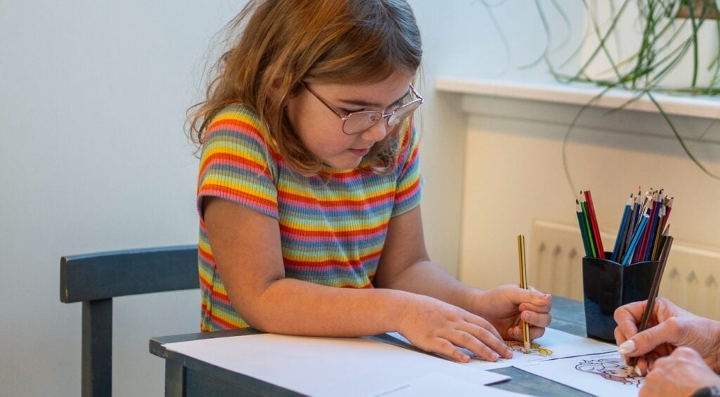 Lille pige maler på og tegner på Epilepsihospitalet, Filadelfia