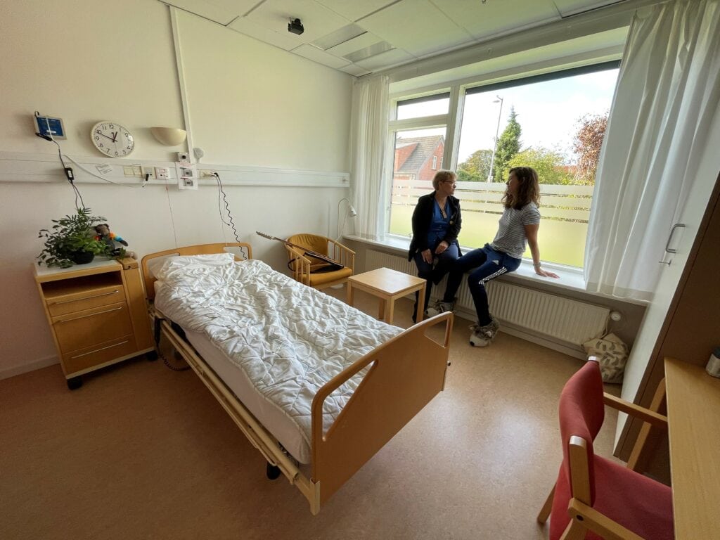 Foto af patientstue med patient og sygeplejerske på Epilepsihospitalet Filadelfia i Dianalund